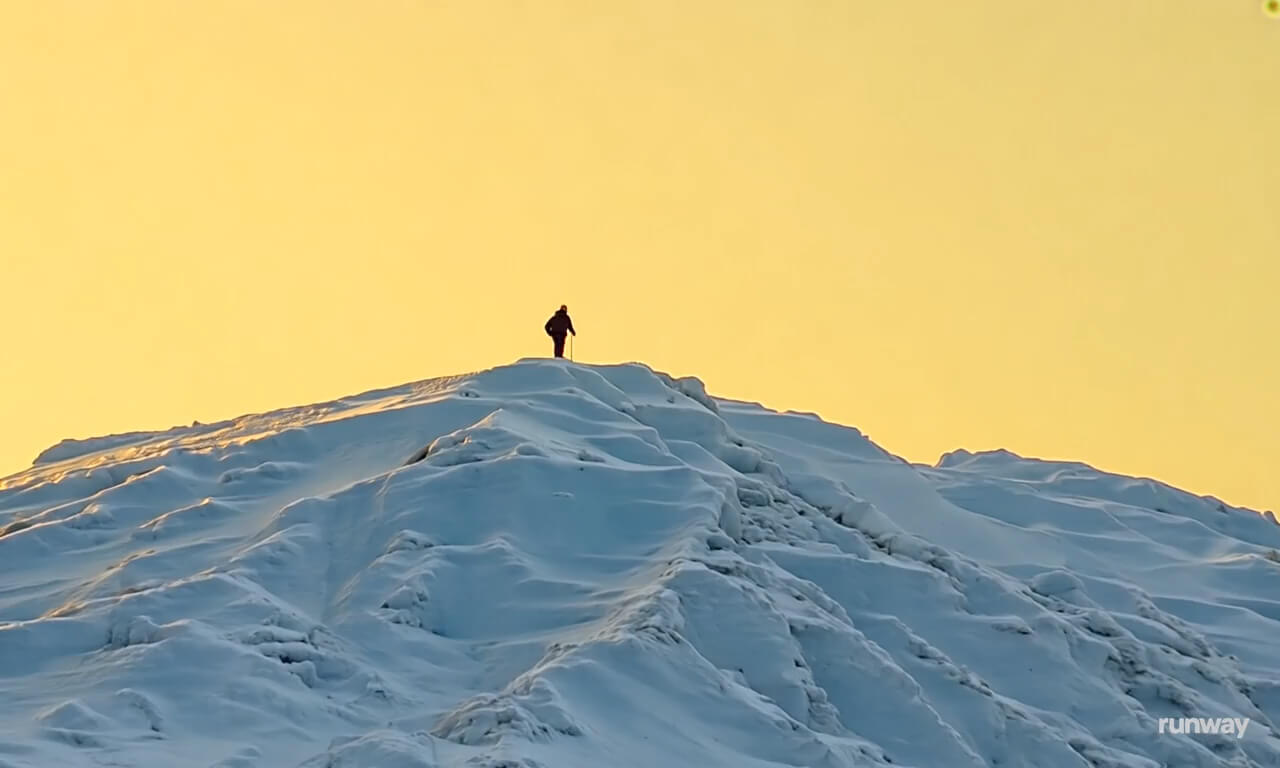 Super fast zoom out from the peak of a frozen mountain where